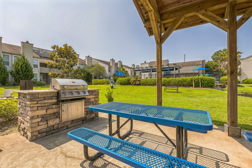 A blue picnic table is in the foreground of a residential area.