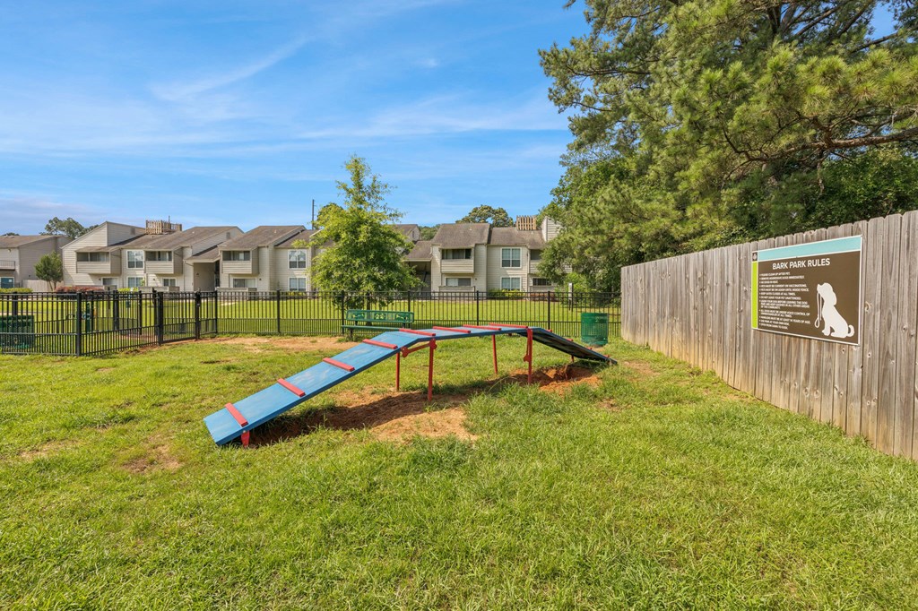 A playground with a slide and a sign on a fence.
