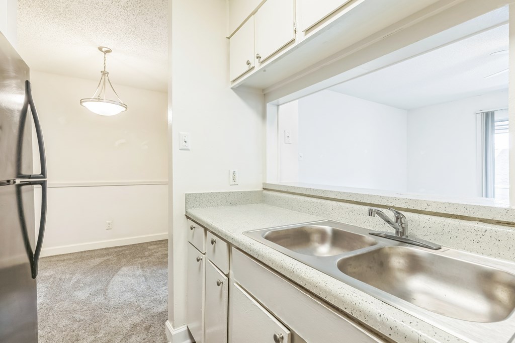 A kitchen with a sink and a refrigerator.