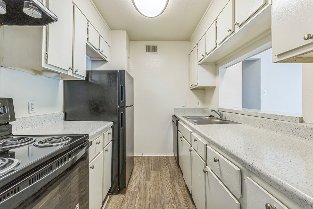 A kitchen with black appliances and white cabinets.