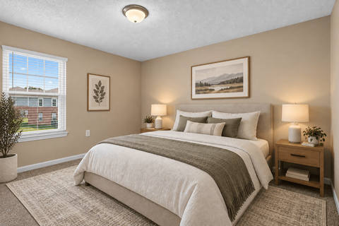 A bedroom with a large bed and a window overlooking a house.