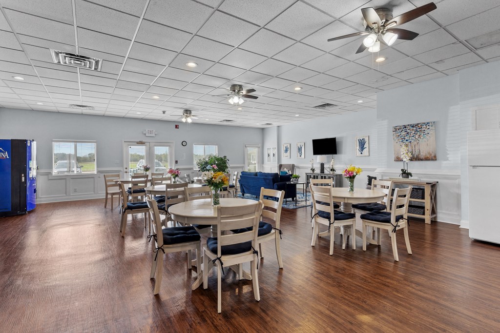 a large room with tables and chairs and a ceiling fan