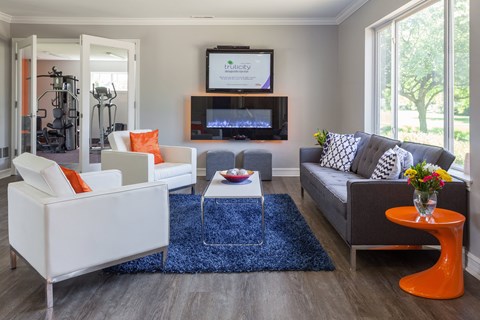 A living room with a grey couch and a white chair.
