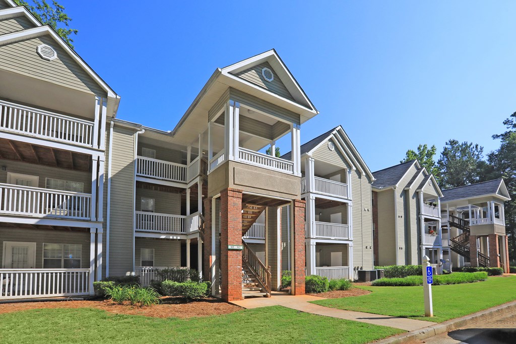 an exterior view of an apartment building with green grass