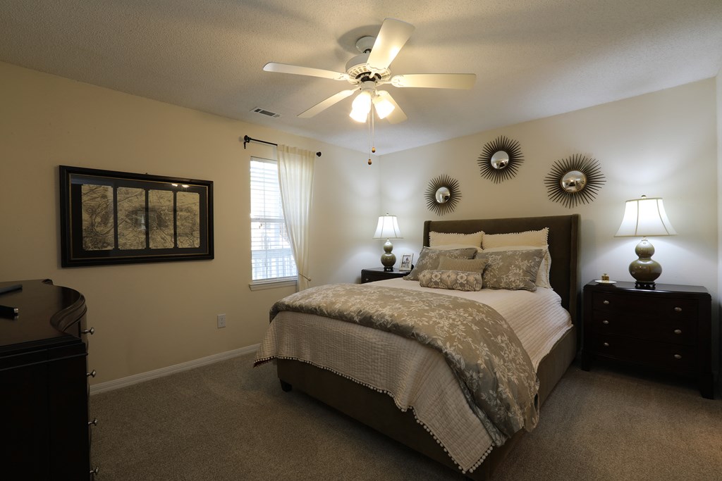 a bedroom with a large bed and a ceiling fan