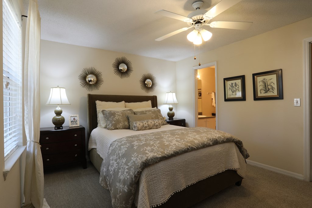 a bedroom with a large bed and a ceiling fan