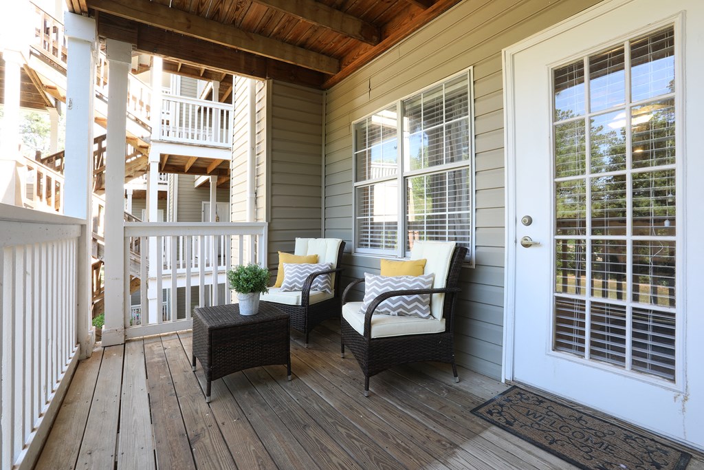a front porch with two chairs and a door