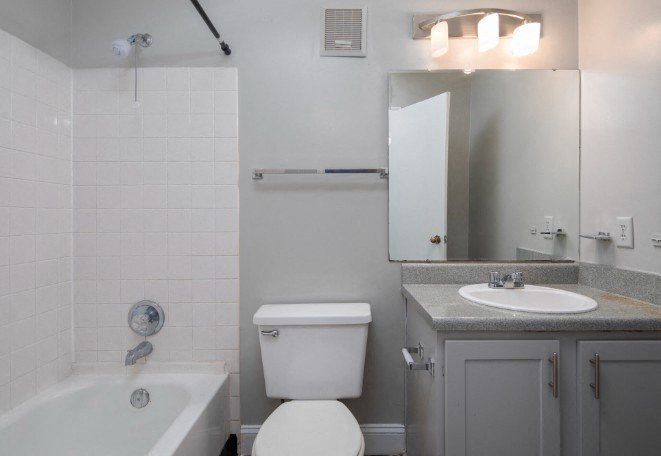 A white toilet sits next to a white sink in a bathroom.