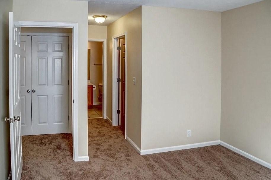 a bedroom with a closet and a door to a hallway