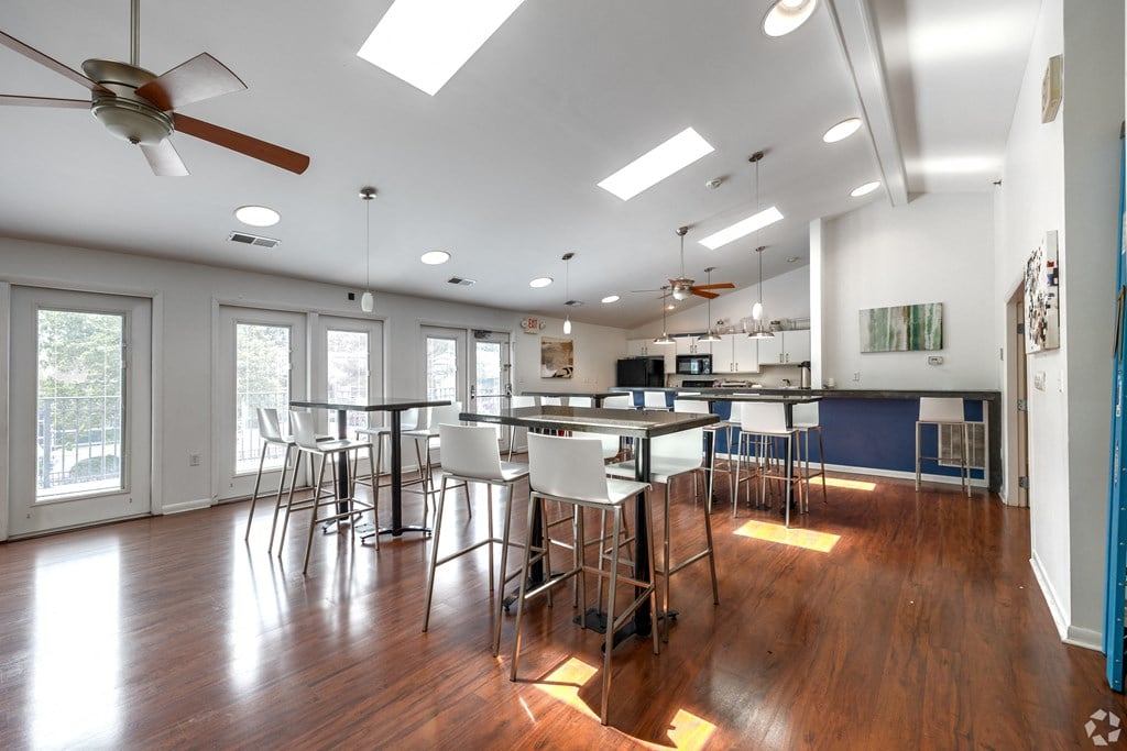a large dining room with a bar and chairs and a kitchen