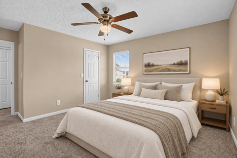 Virtually staged bedroom with a large bed and ceiling fan at Arbours at Victoria Place in Prattville, AL