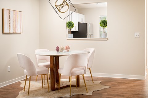 A dining room with a white table and chairs.