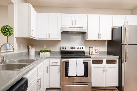 A modern kitchen with white cabinets and stainless steel appliances.