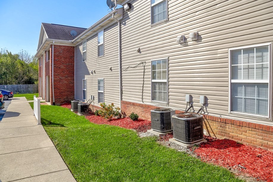 a side view of a house with a yard and a sidewalk