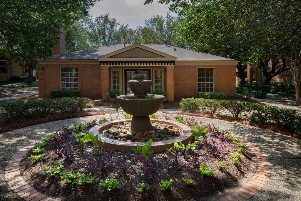 a fountain in front of a brick building