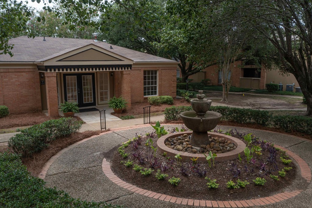 a fountain in front of a brick building