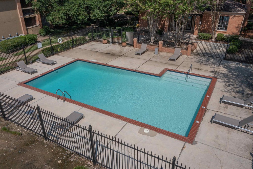 a pool with a fence around it and a building in the background