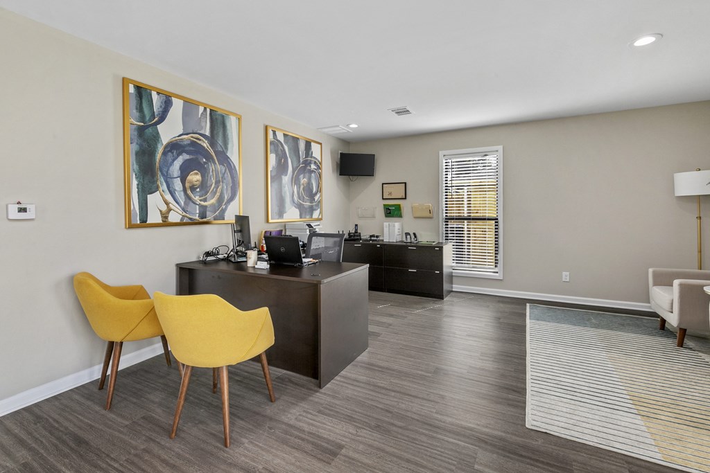 an office with yellow chairs and a desk and a window