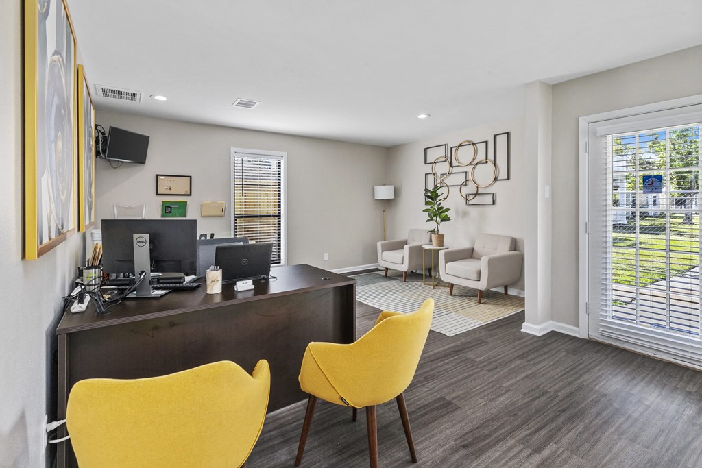 an office with yellow chairs and a desk and a window