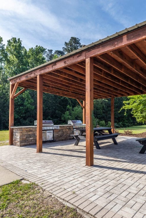 a pavilion with a stone fireplace and picnic table