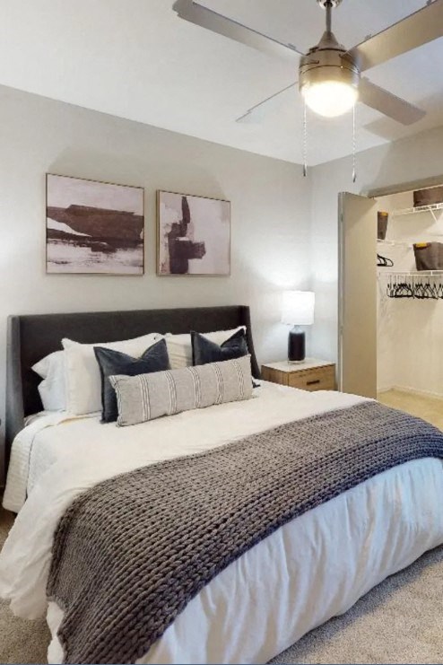 a bedroom with a bed and a ceiling fan