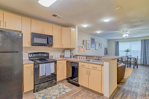 A kitchen with wooden cabinets and a black refrigerator.