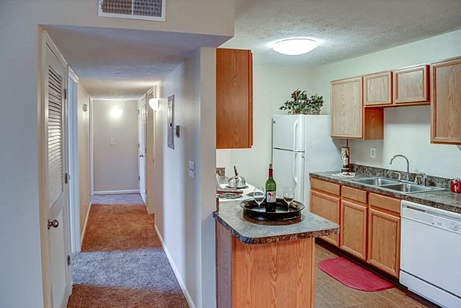 a kitchen with a counter with a bottle of wine