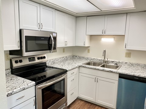 A kitchen with white cabinets and a black stove top oven.