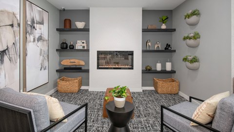 A living room with grey couches, a coffee table, and a fireplace.