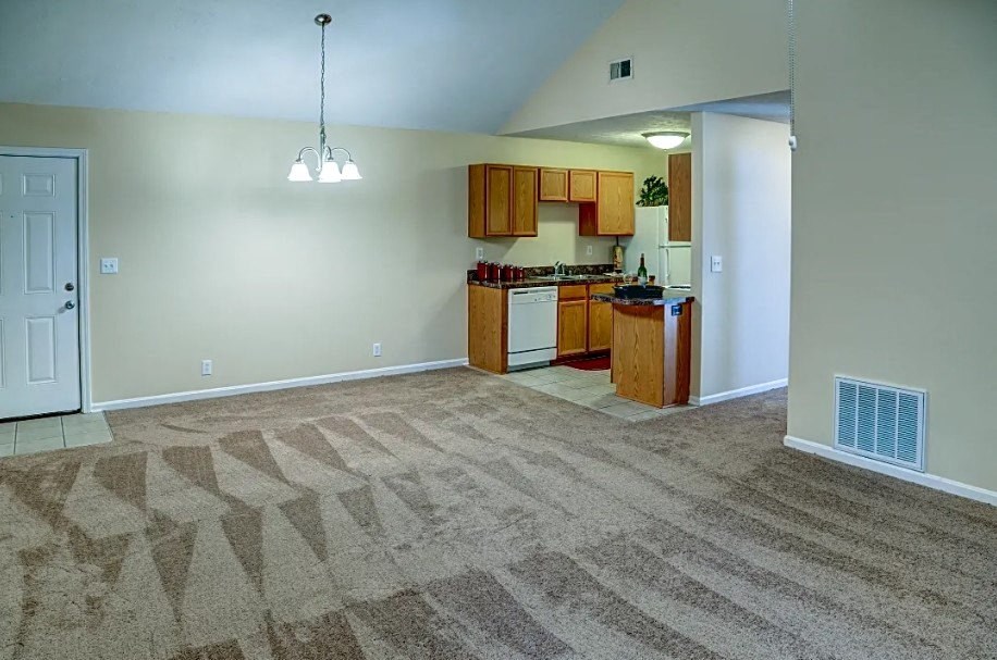 an empty living room with a kitchen and