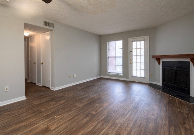 A room with wooden floors and a fireplace.