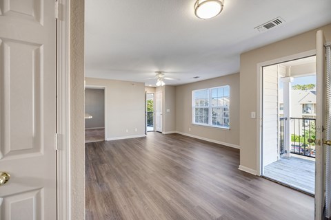 A spacious room with wooden floors and white walls.