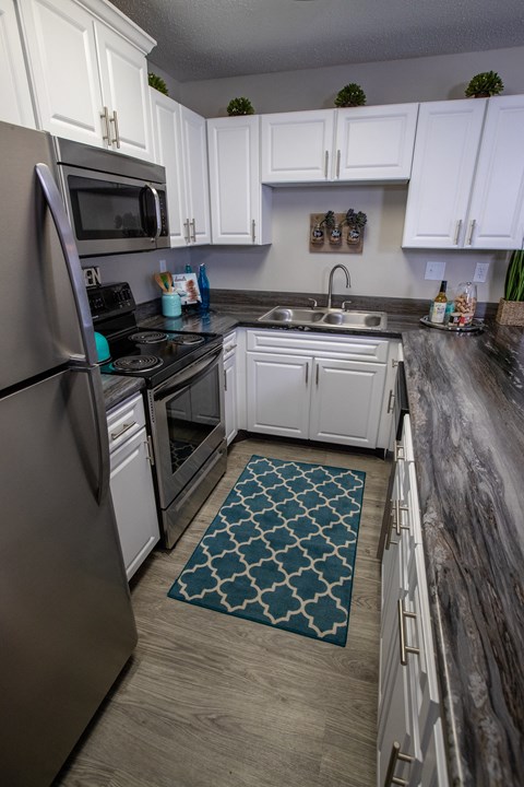 a kitchen with stainless steel appliances and white cabinets