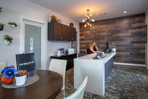 a woman sitting at a desk in a kitchen and dining room