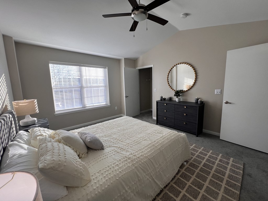 a bedroom with a large bed and a ceiling fan
