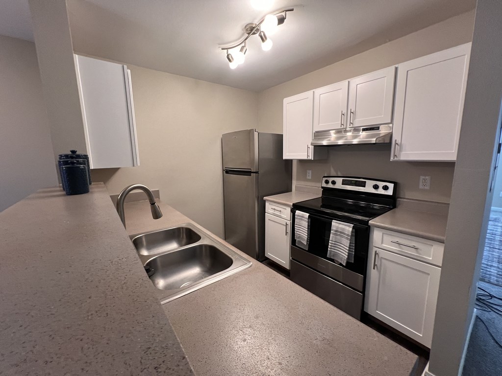 a kitchen with stainless steel appliances and white cabinets