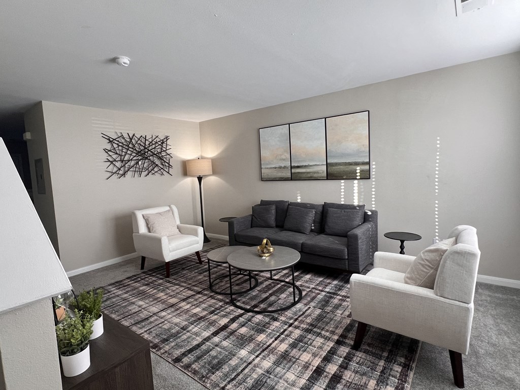 a living room with couches and chairs and a rug