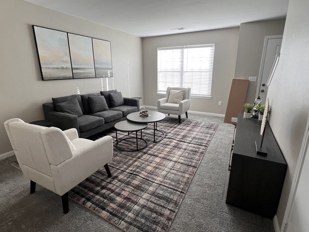 a living room with couches and chairs and a rug