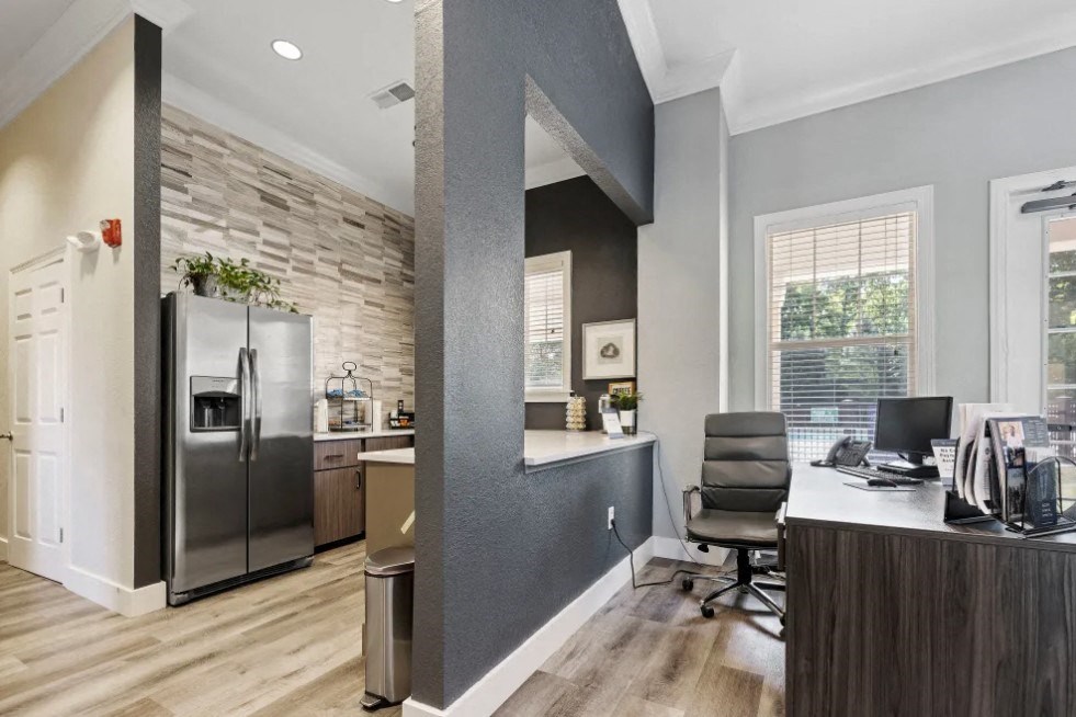 a kitchen with a refrigerator freezer next to a desk with a computer