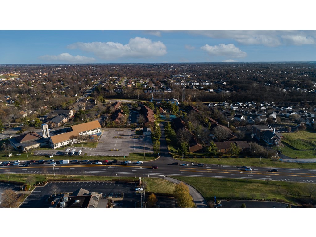 an aerial view of a city with a highway in the foreground and houses in the background
