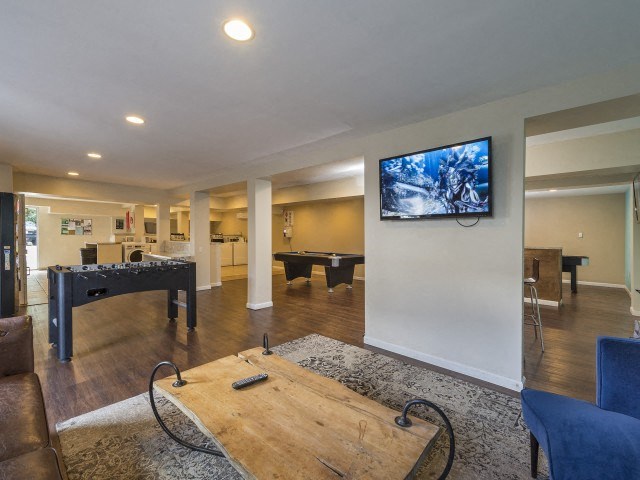 a game room with a foosball table and a flat screen tv