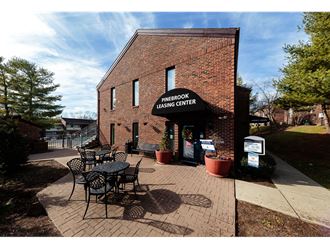 a brick building with a patio with tables and chairs