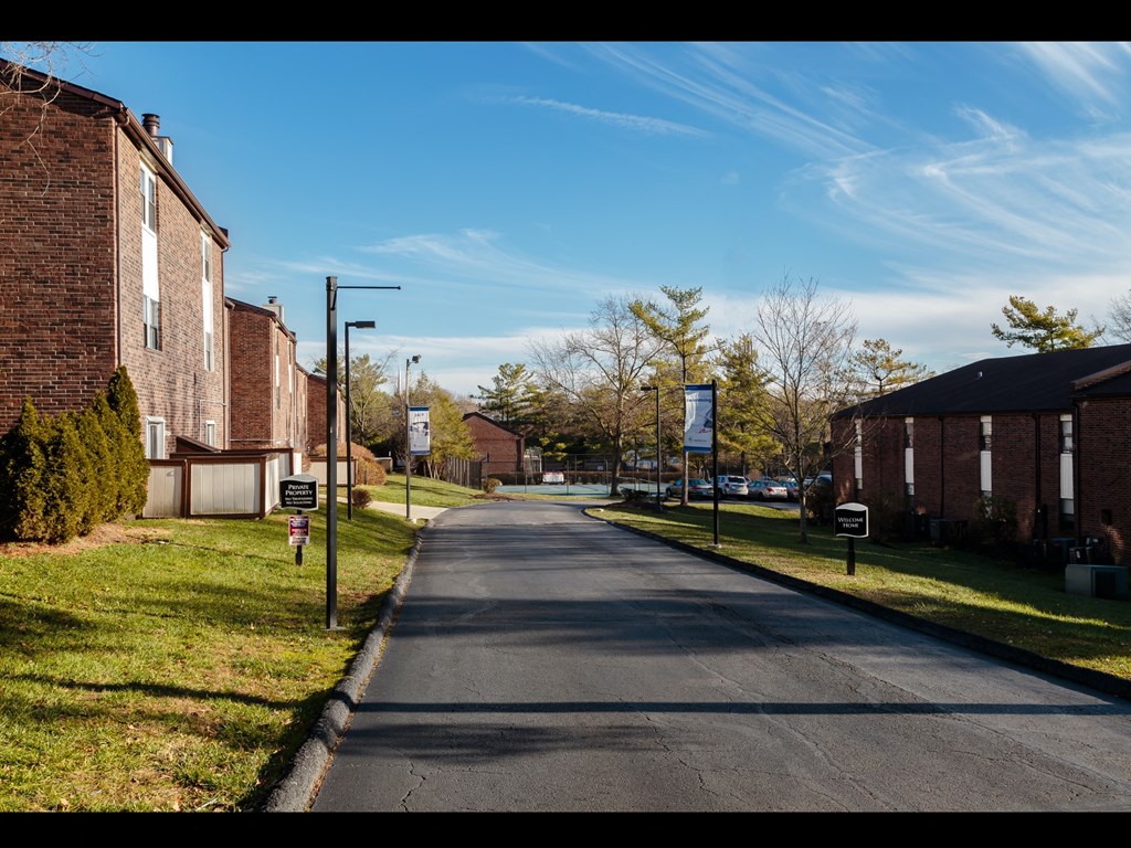 a street with brick buildings on either side and a blue sky in the background