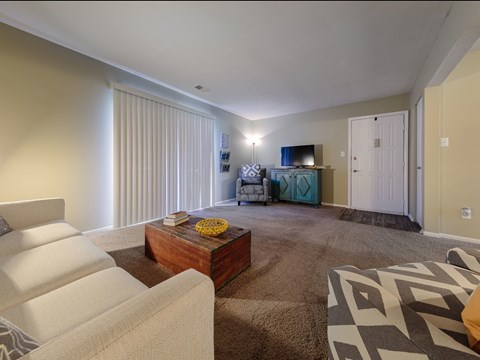 A living room with a white couch and a wooden coffee table.