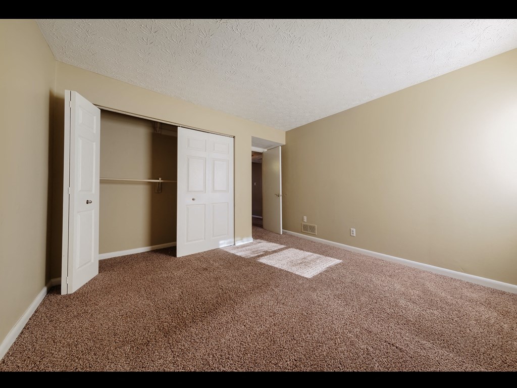 a bedroom with a closet and a door that is open