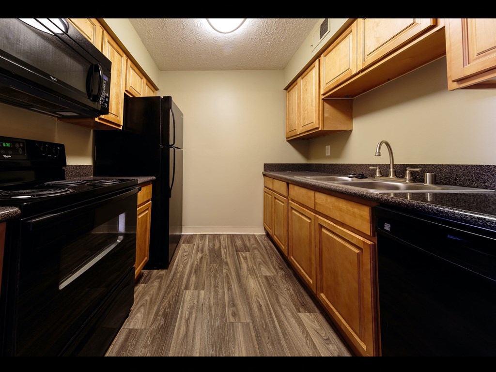 a kitchen with black appliances and wood cabinets