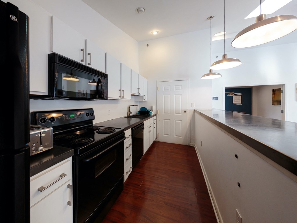 a kitchen with white cabinets and black appliances