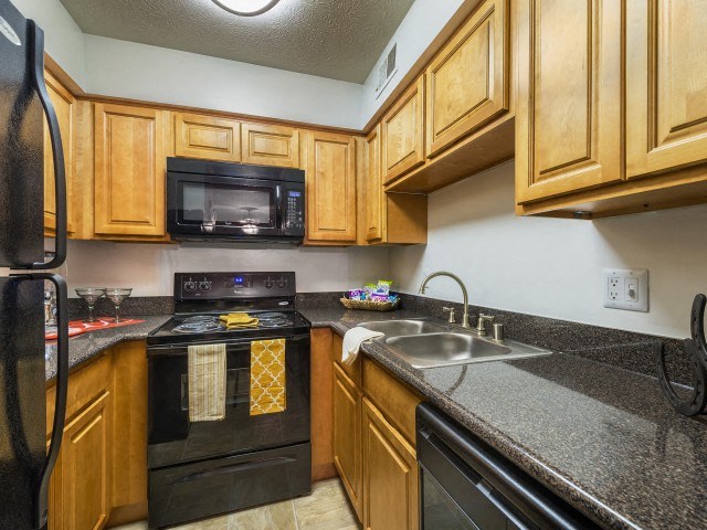 a kitchen with wood cabinets and black appliances