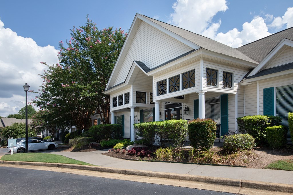 a white house with blue shutters and a white car parked in front of it