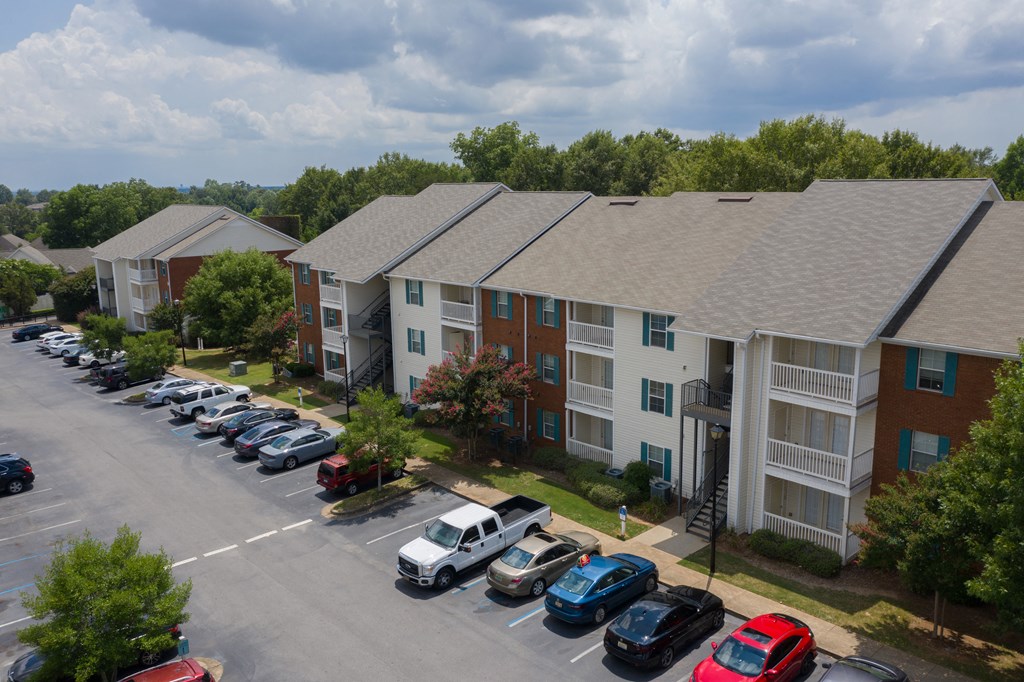 an aerial view of an apartment complex with a parking lot